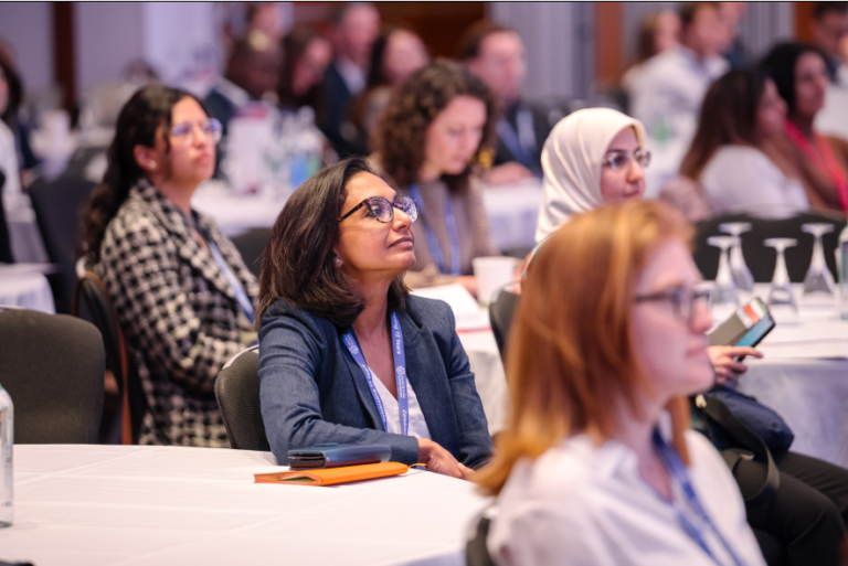 Audience members attending a scientific conference session focused on mRNA therapeutics, drug delivery, and nucleic acid medicine development.