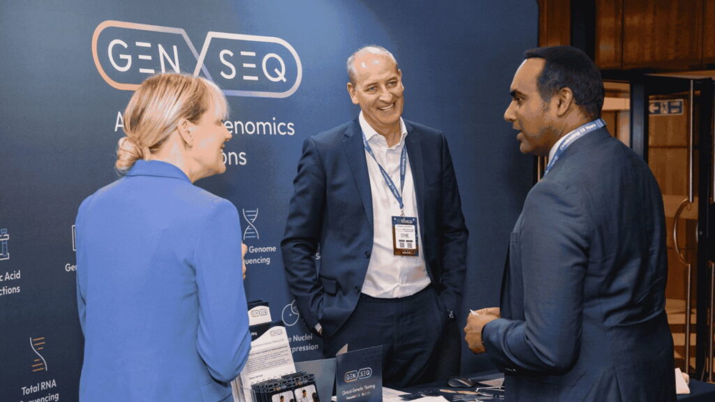 Sponsor representative engaging with attendees at an exhibition stand during the 6th mRNA-Based Therapeutics & Non-Viral Delivery Summit Europe.